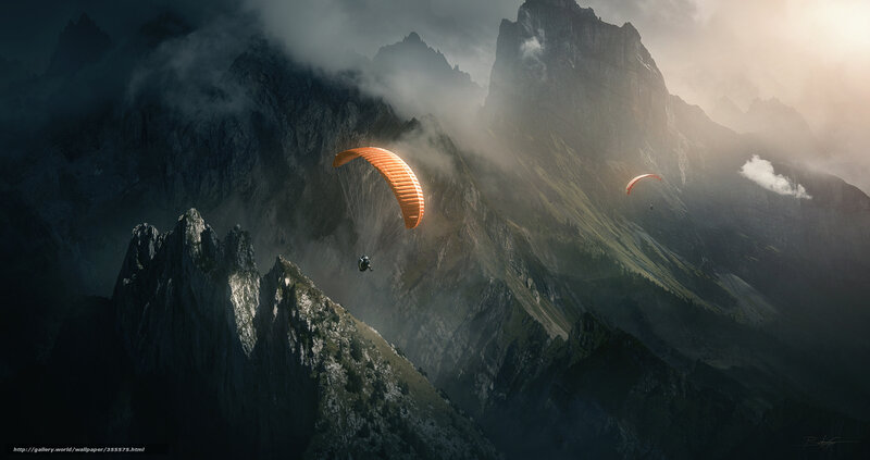 Paragliders over misty mountains