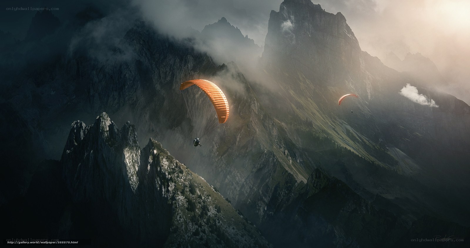 Paragliders over misty mountains