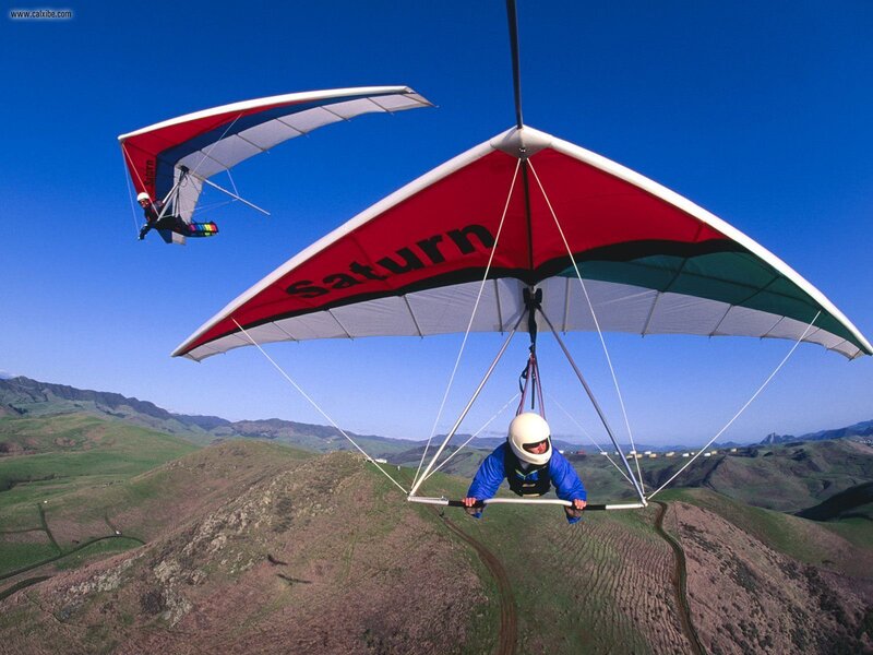 Paragliders soaring over hills