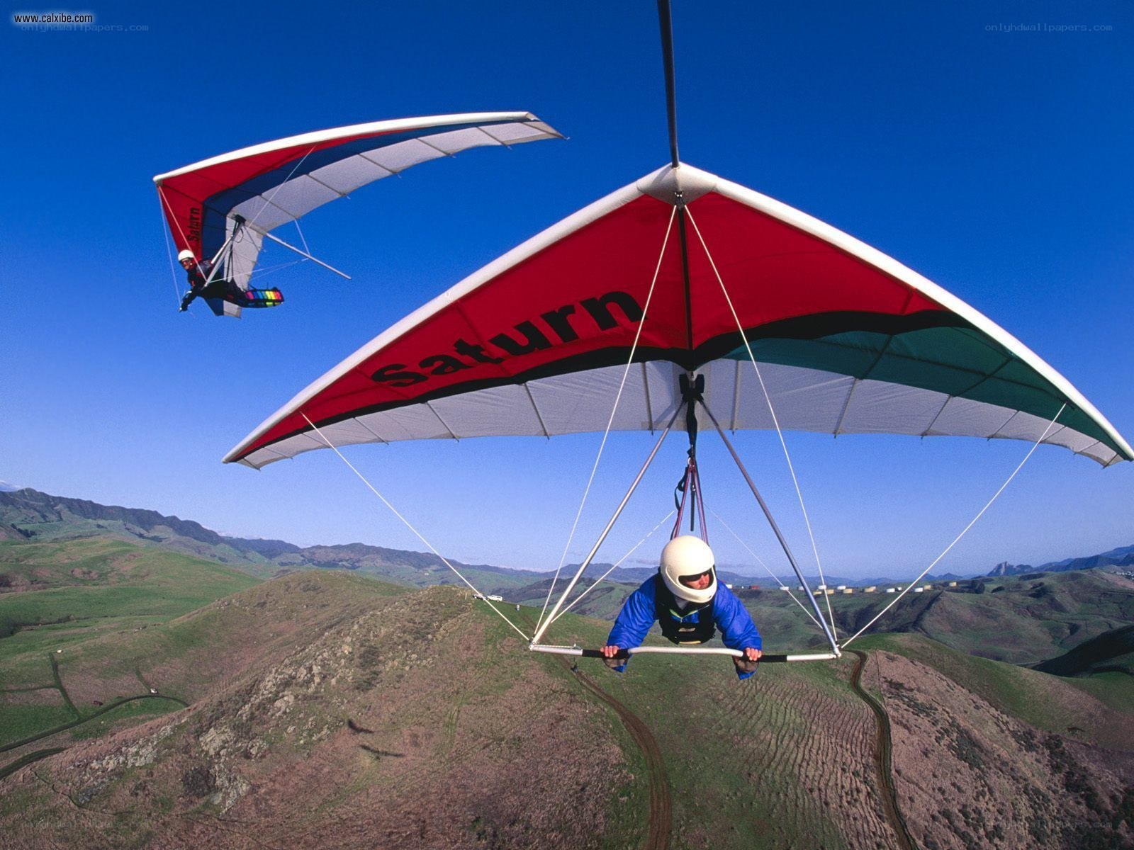 Paragliders soaring over hills