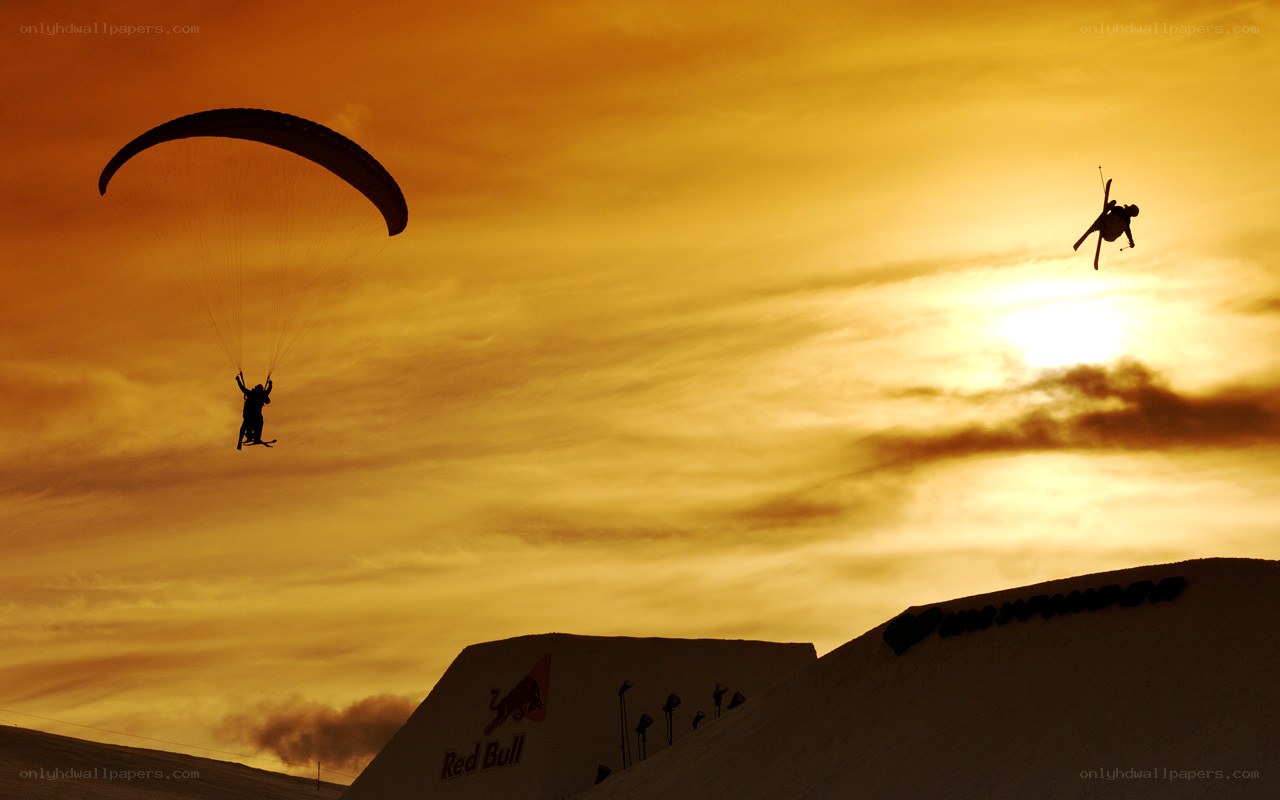 Paragliding and skiing at sunset