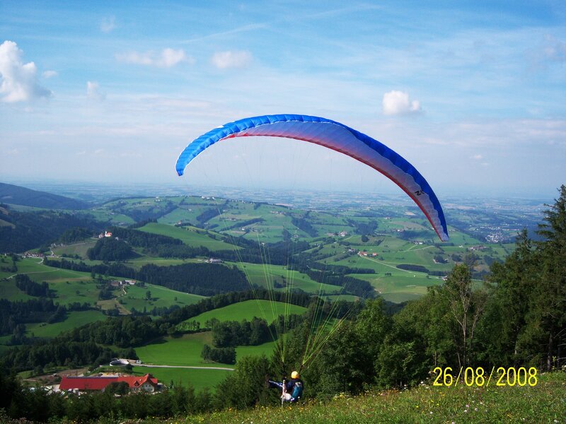 Paragliding over green hills