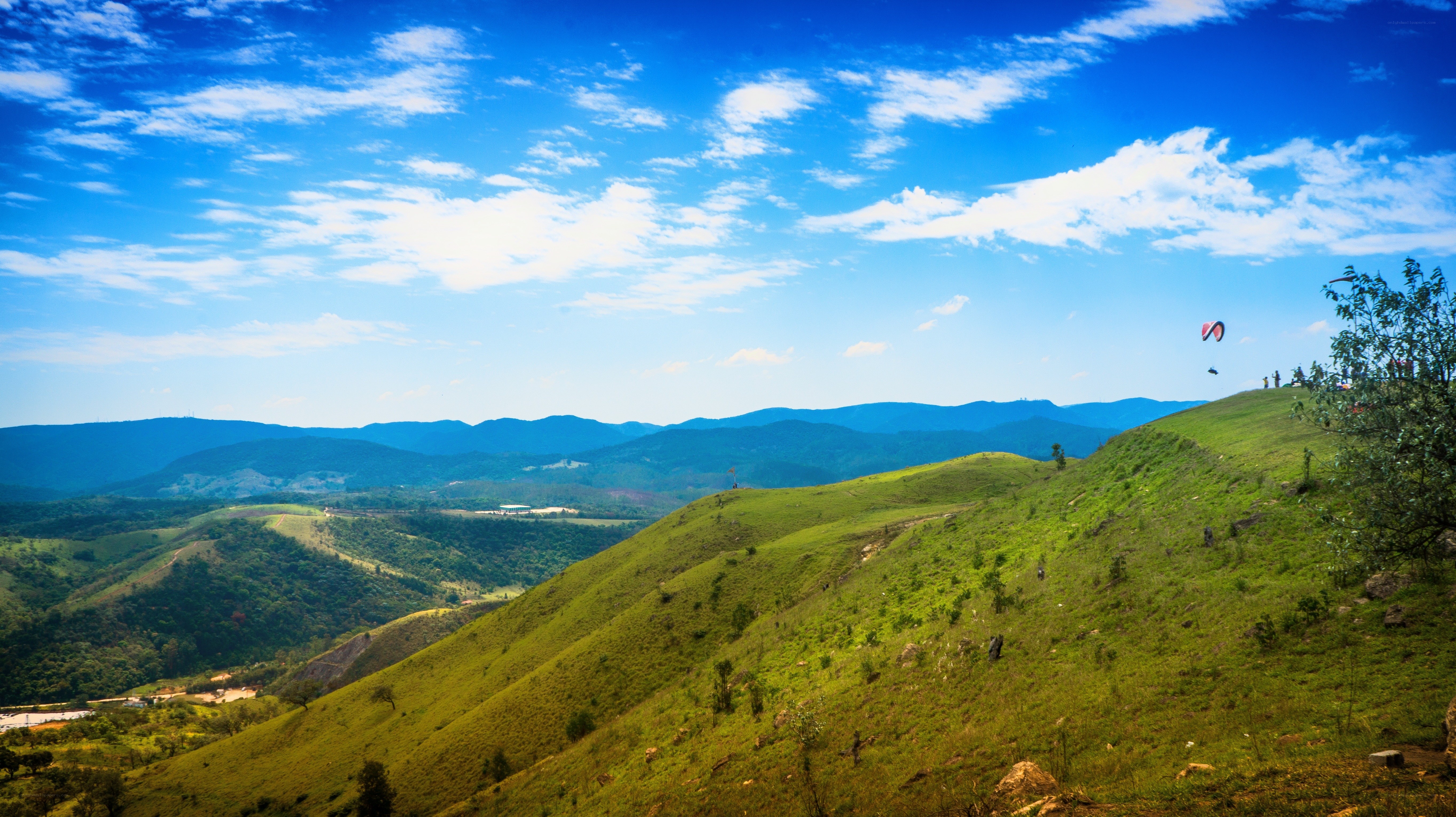Paragliding over green hills