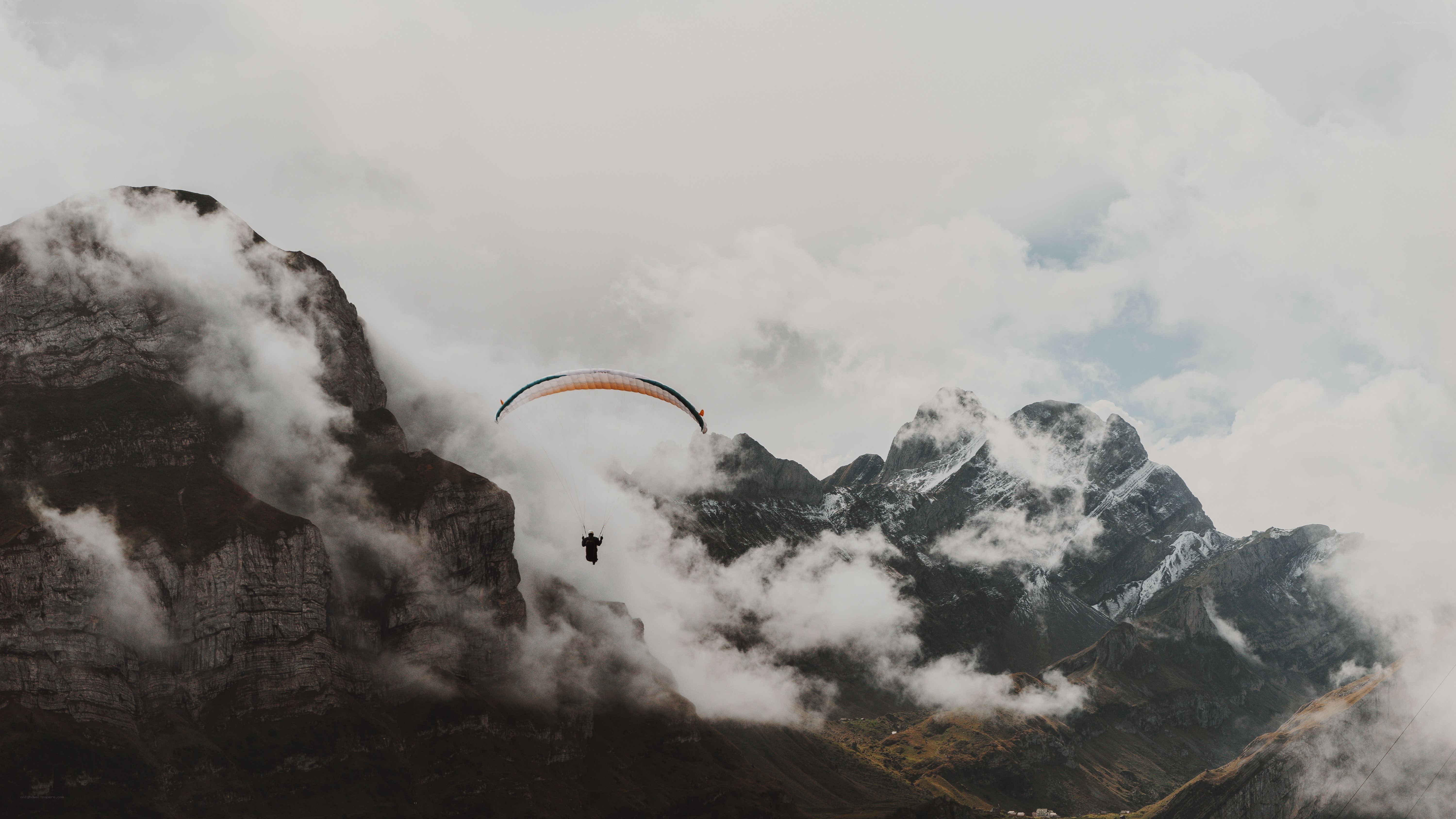 Paragliding over misty mountains
