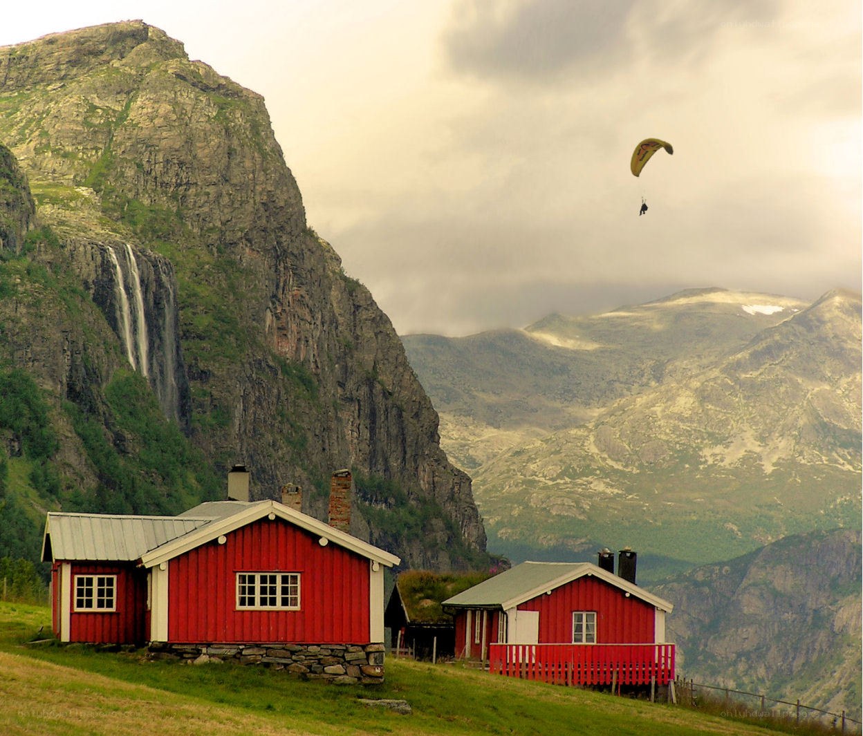 Paragliding over red cabins