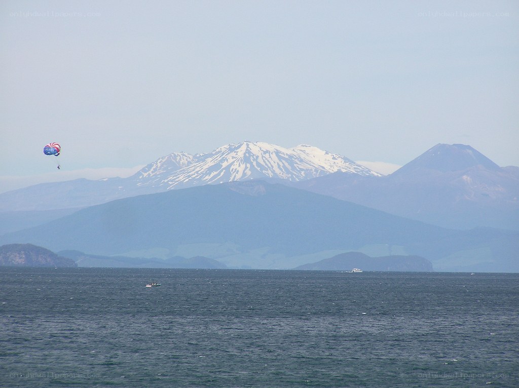Parasailing over a lake with mountains