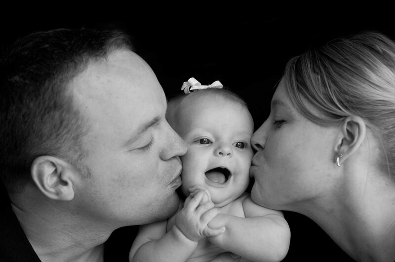 Parents Kissing Baby