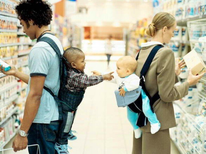 Parents with babies in carriers at store