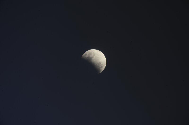 Partial lunar eclipse in night sky