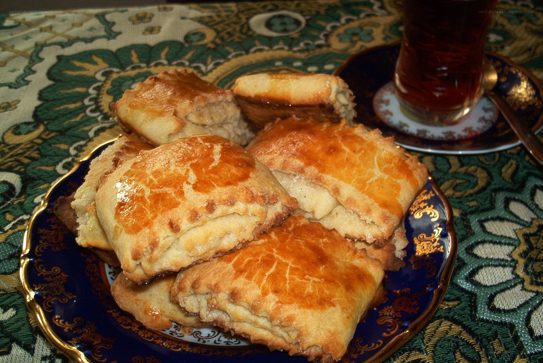 Pastries with tea on a patterned table