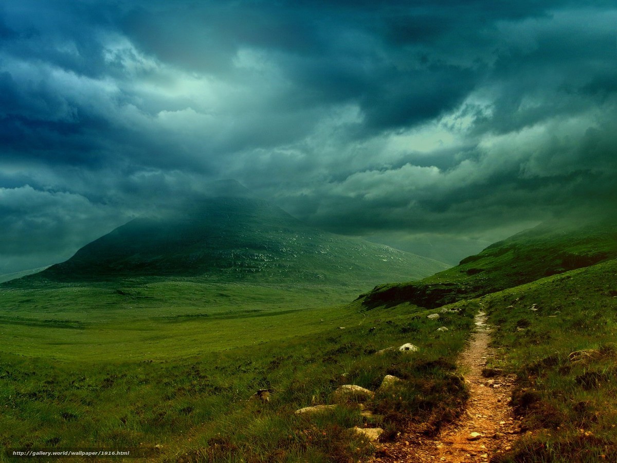 Path to the mountain under stormy sky