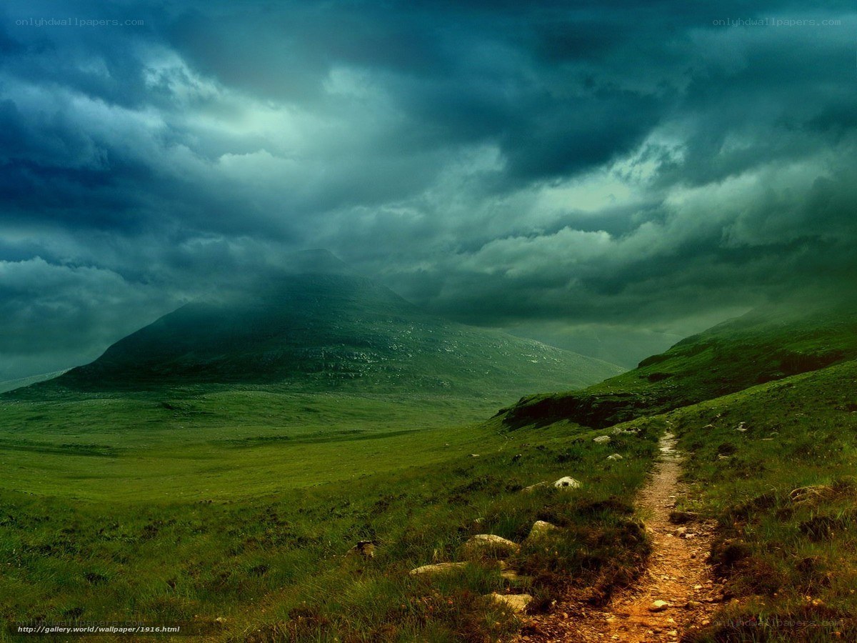 Path to the mountain under stormy sky