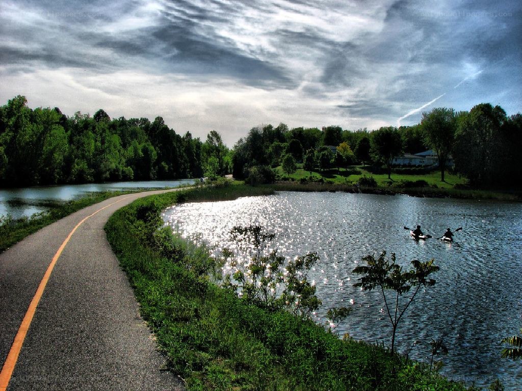 Paved path along a lake with kayakers