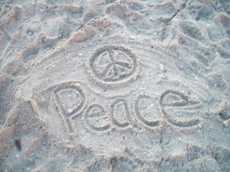Peace symbol carved in sand