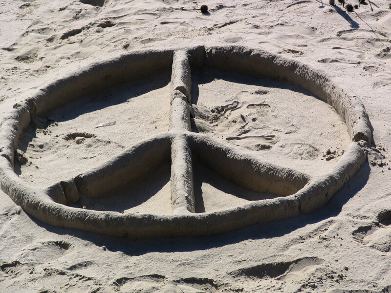 Peace symbol carved in sand