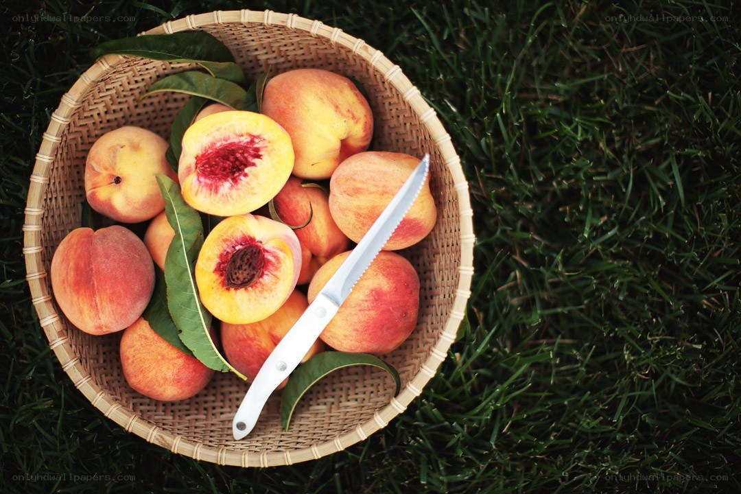 Peaches in a basket on grass