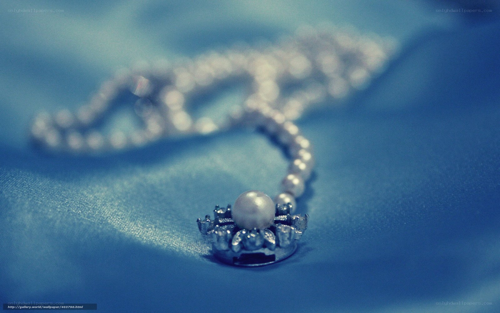 pearl necklace on blue fabric