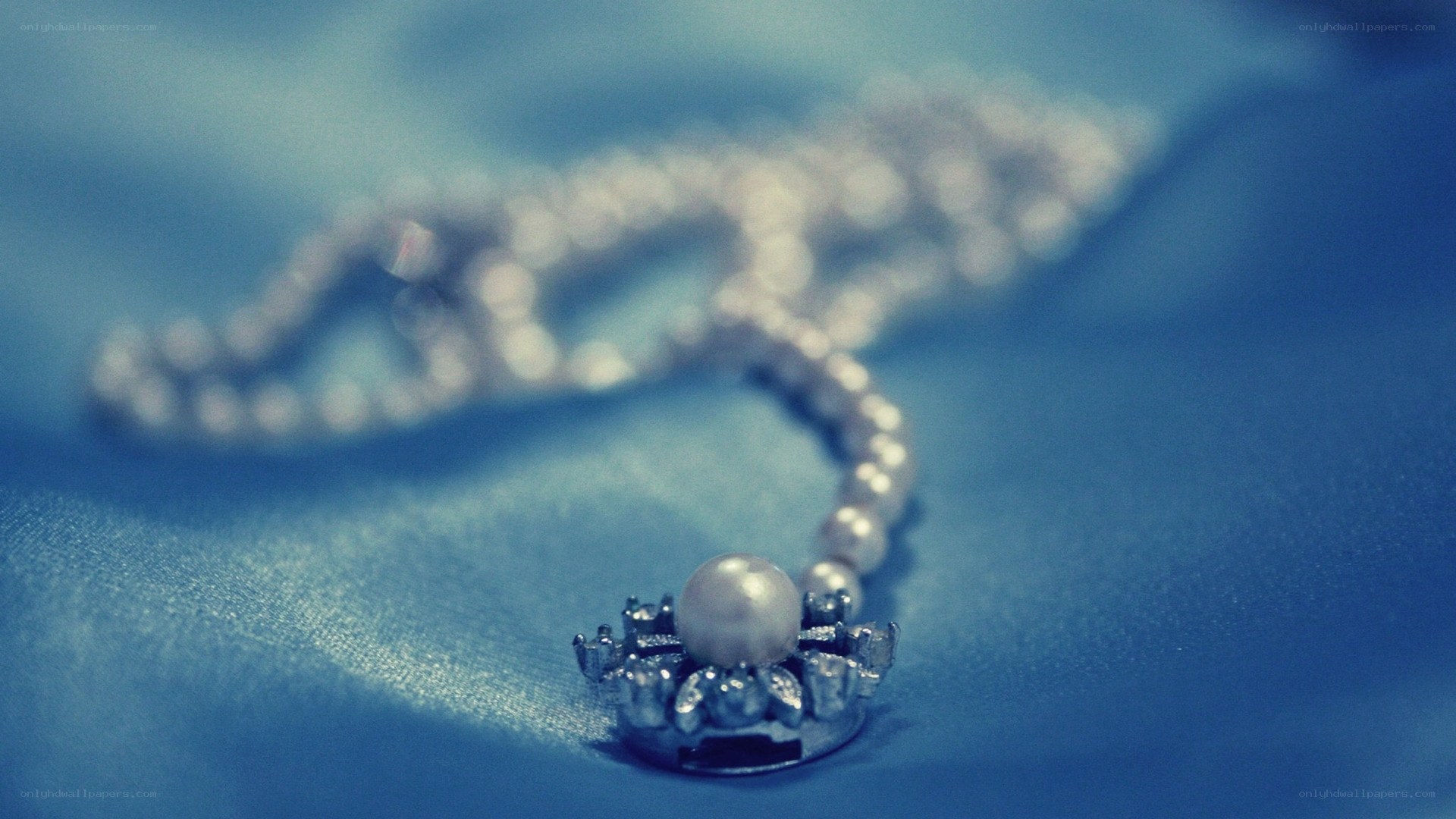 pearl necklace on blue fabric