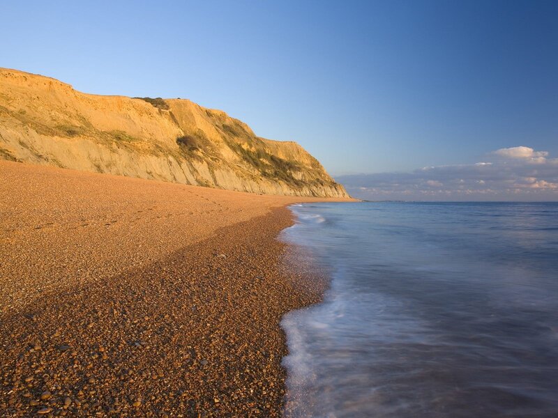 pebble beach with cliffs at sunset