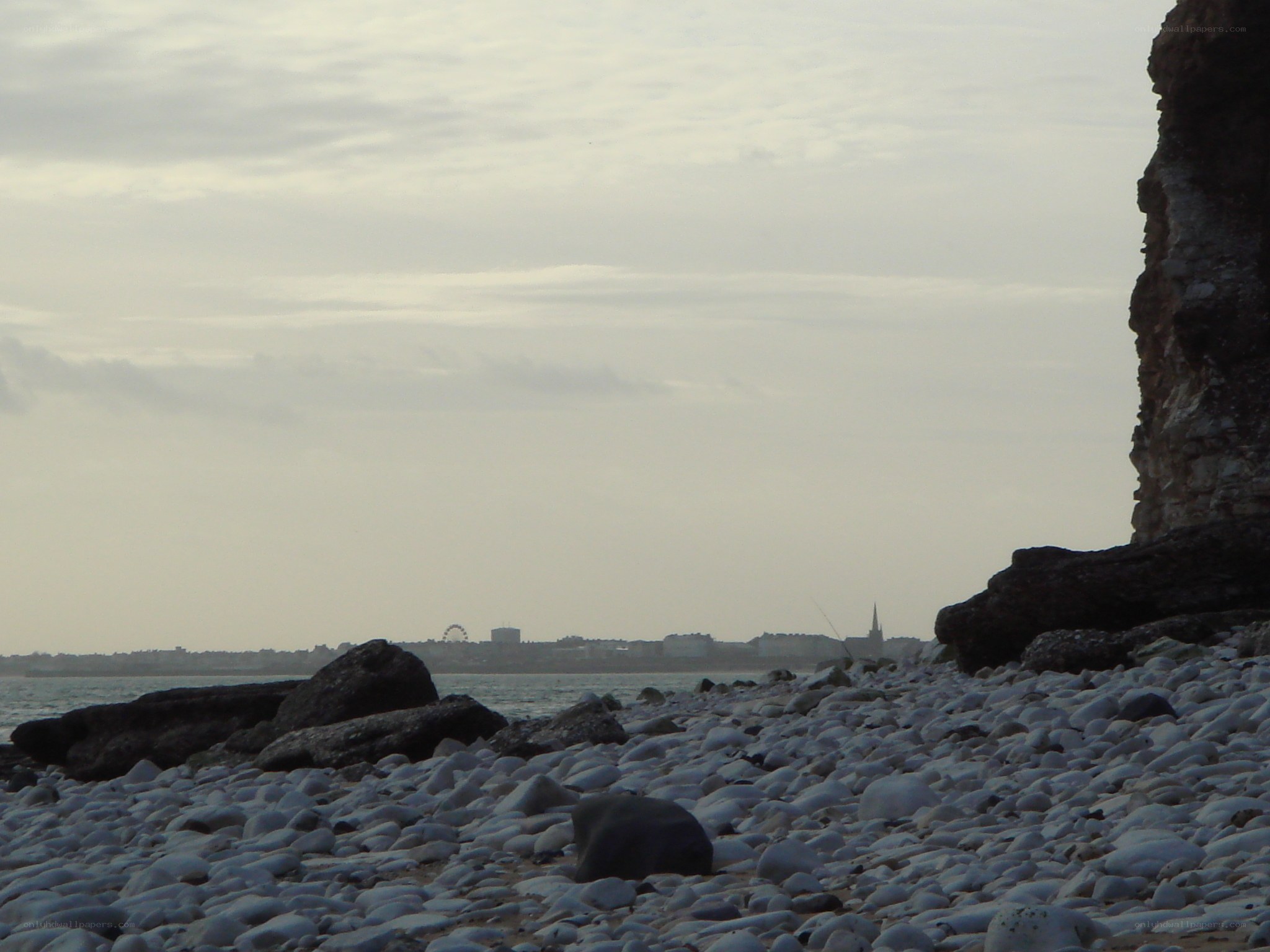 pebble beach with distant city