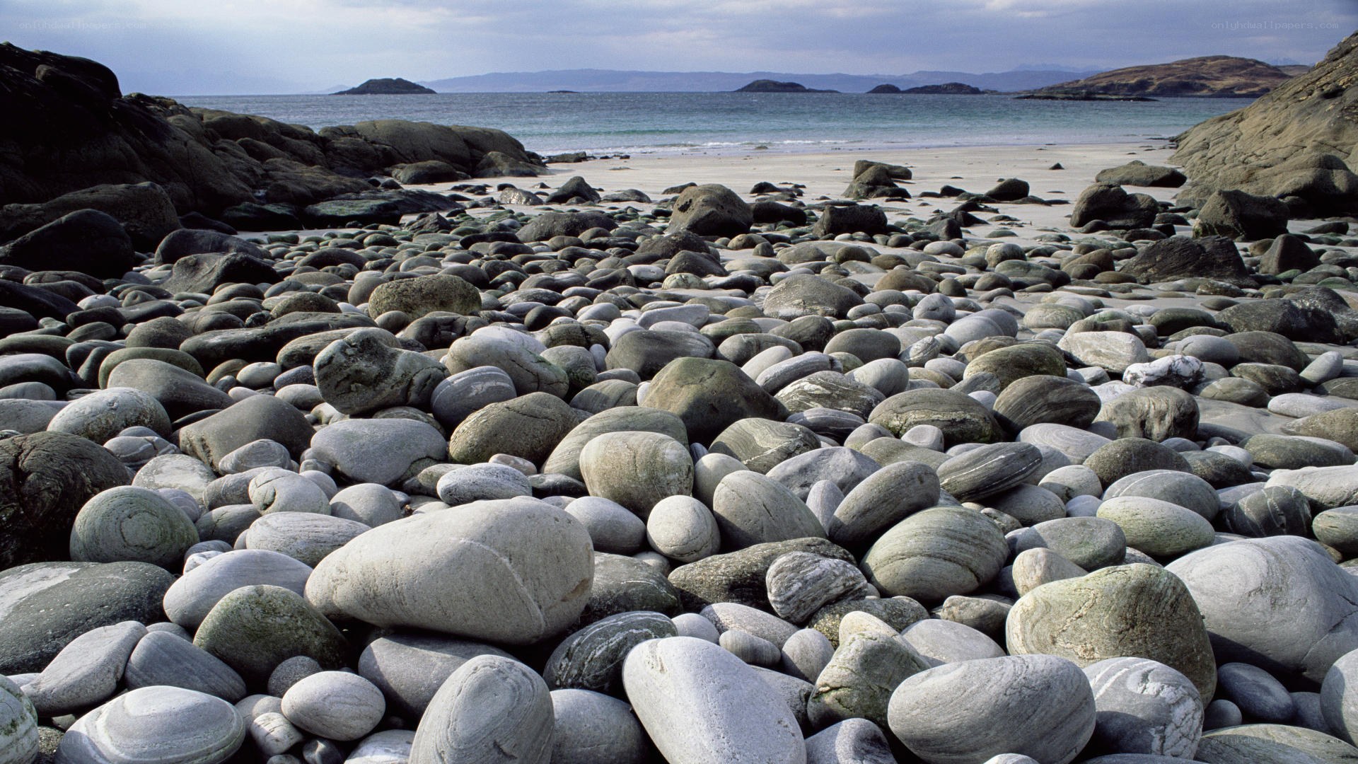 pebble beach with distant islands