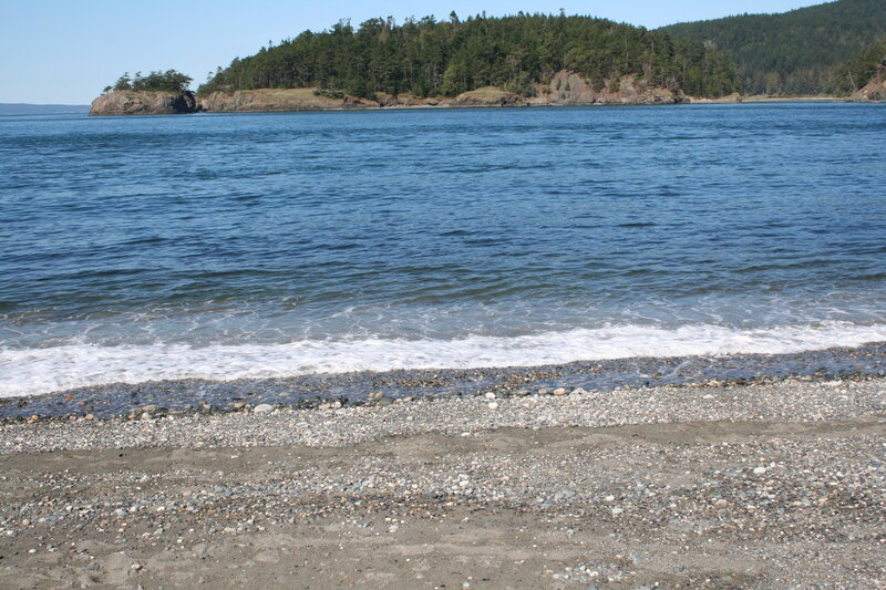 pebble beach with forested island
