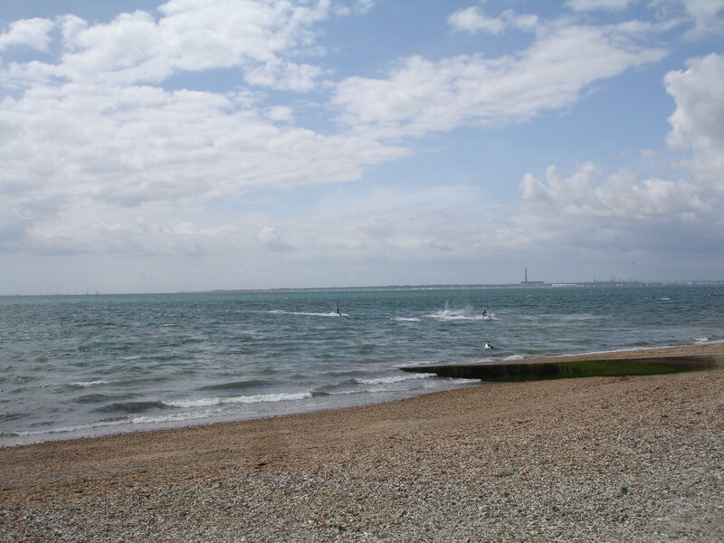 pebble beach with windsurfers