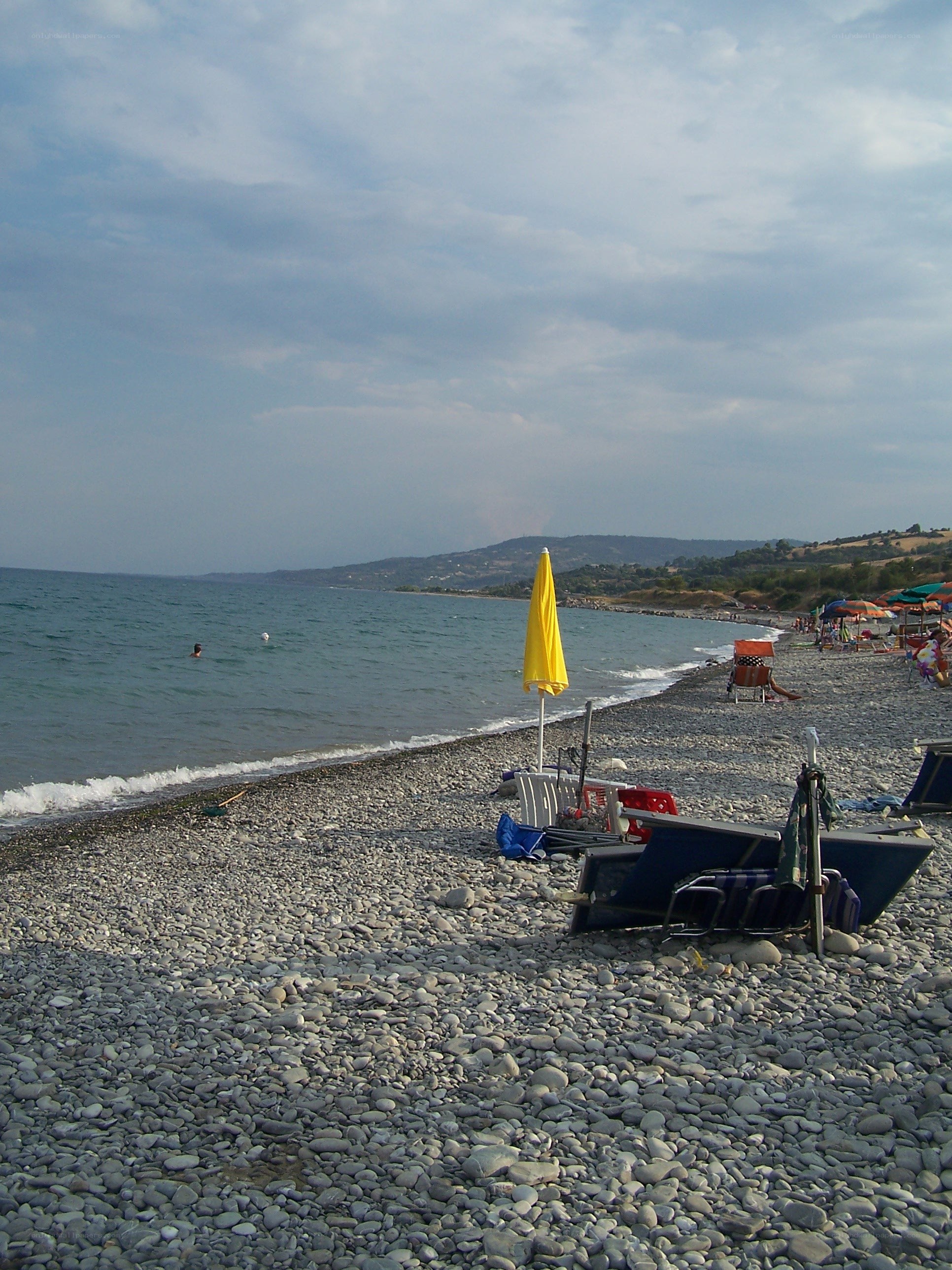 pebble beach with yellow umbrella