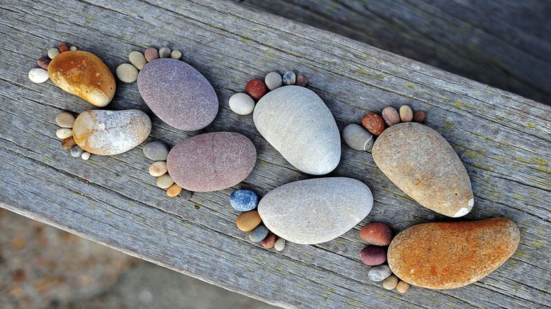 Pebble foot art on wood