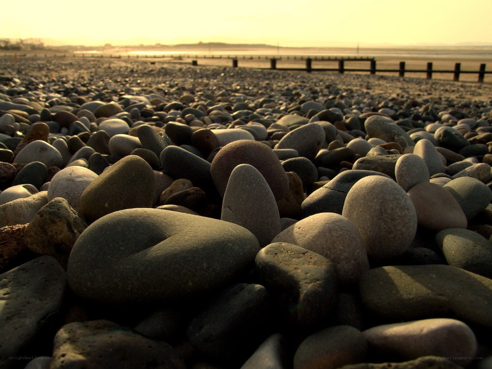 pebbles on a beach at sunset