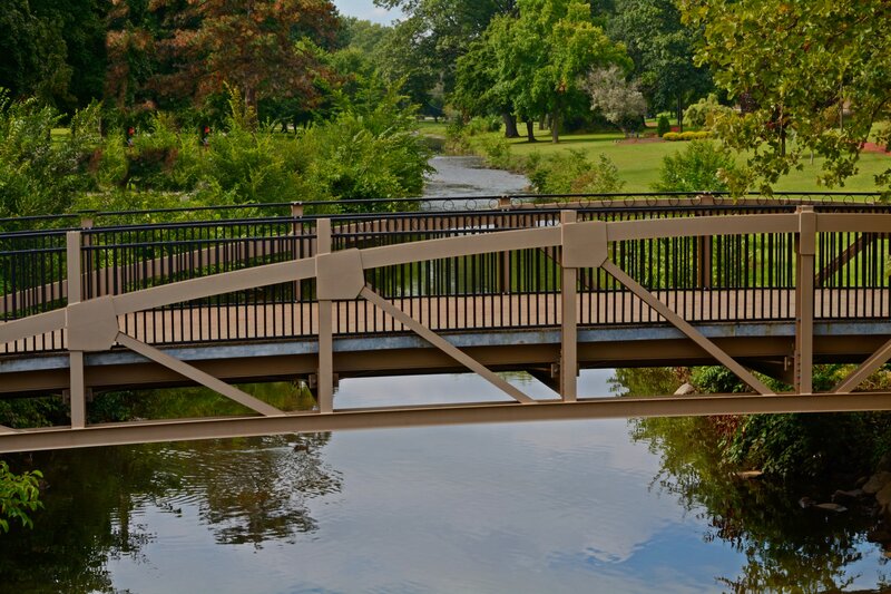 Pedestrian Bridge over River — Green, Serene, Afternoon