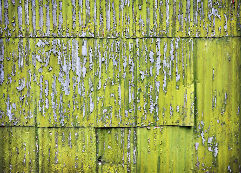 peeling green paint on metal wall