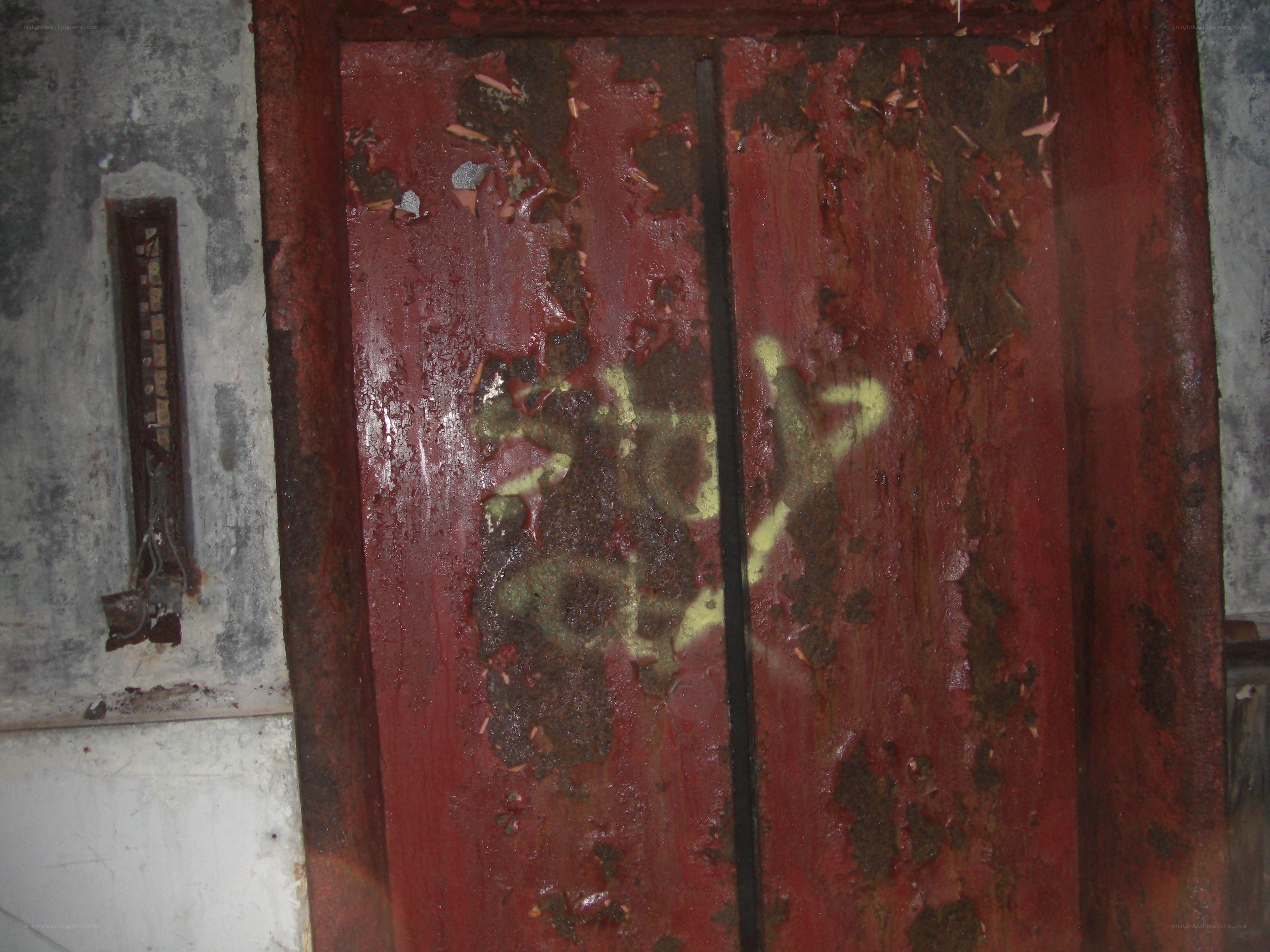peeling red door with graffiti