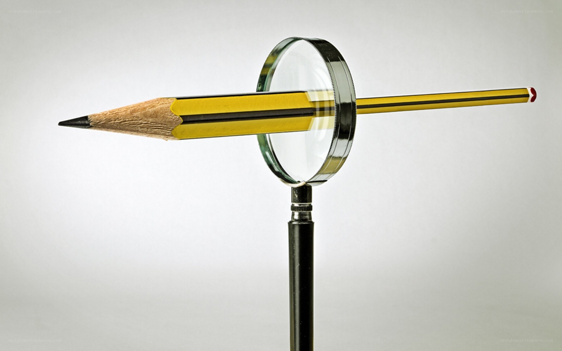 Pencil through magnifying glass