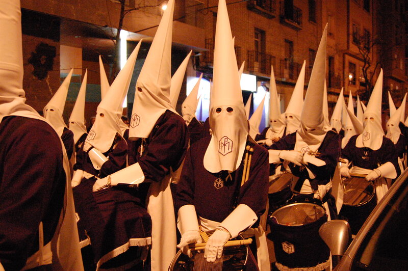 Penitents in white hoods at night
