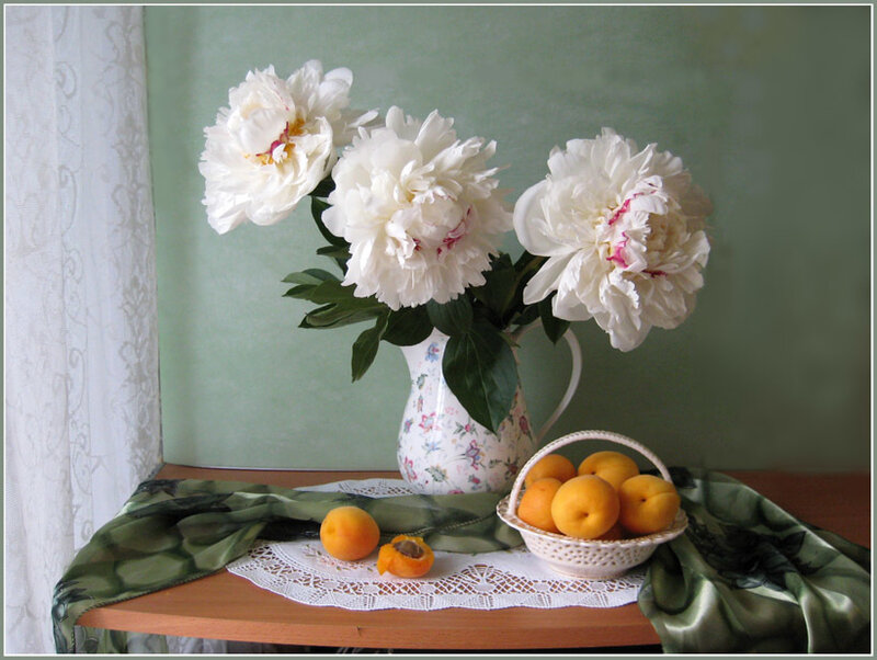 Peonies and apricots on a table