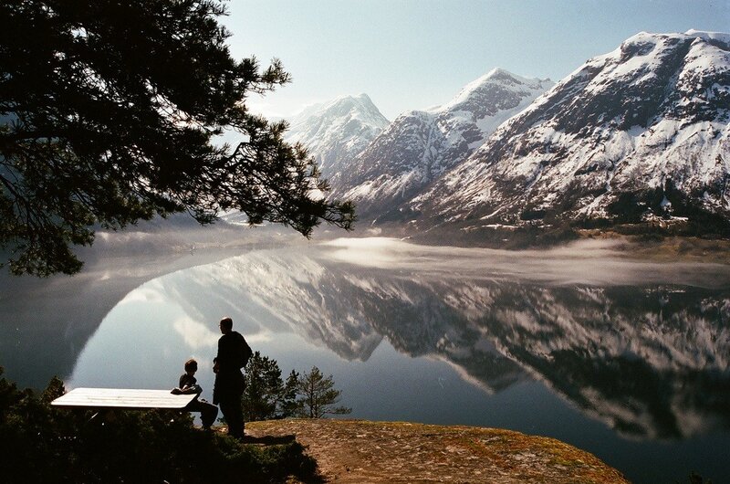 People at a lake with mountains