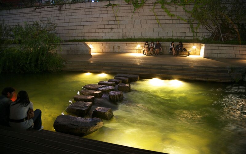 People at a riverside park at night