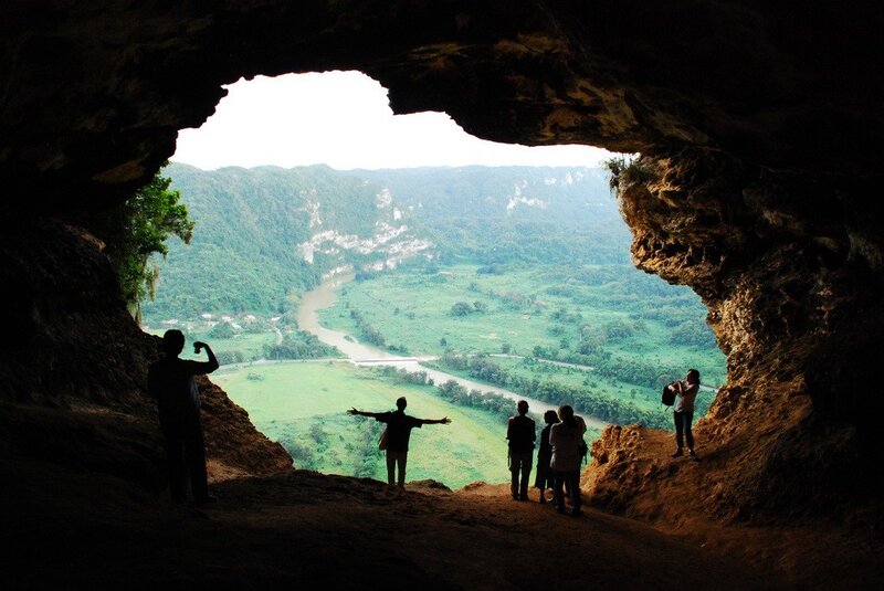 People at cave entrance viewing valley