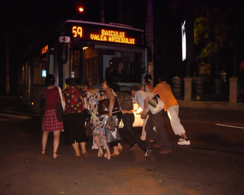 People boarding a bus at night