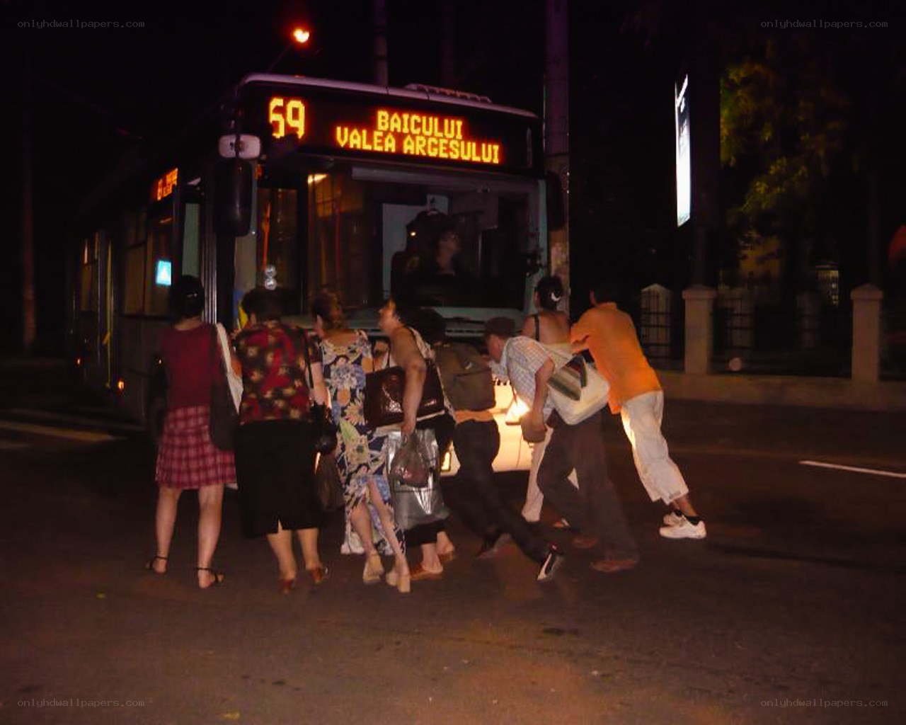 People boarding a bus at night