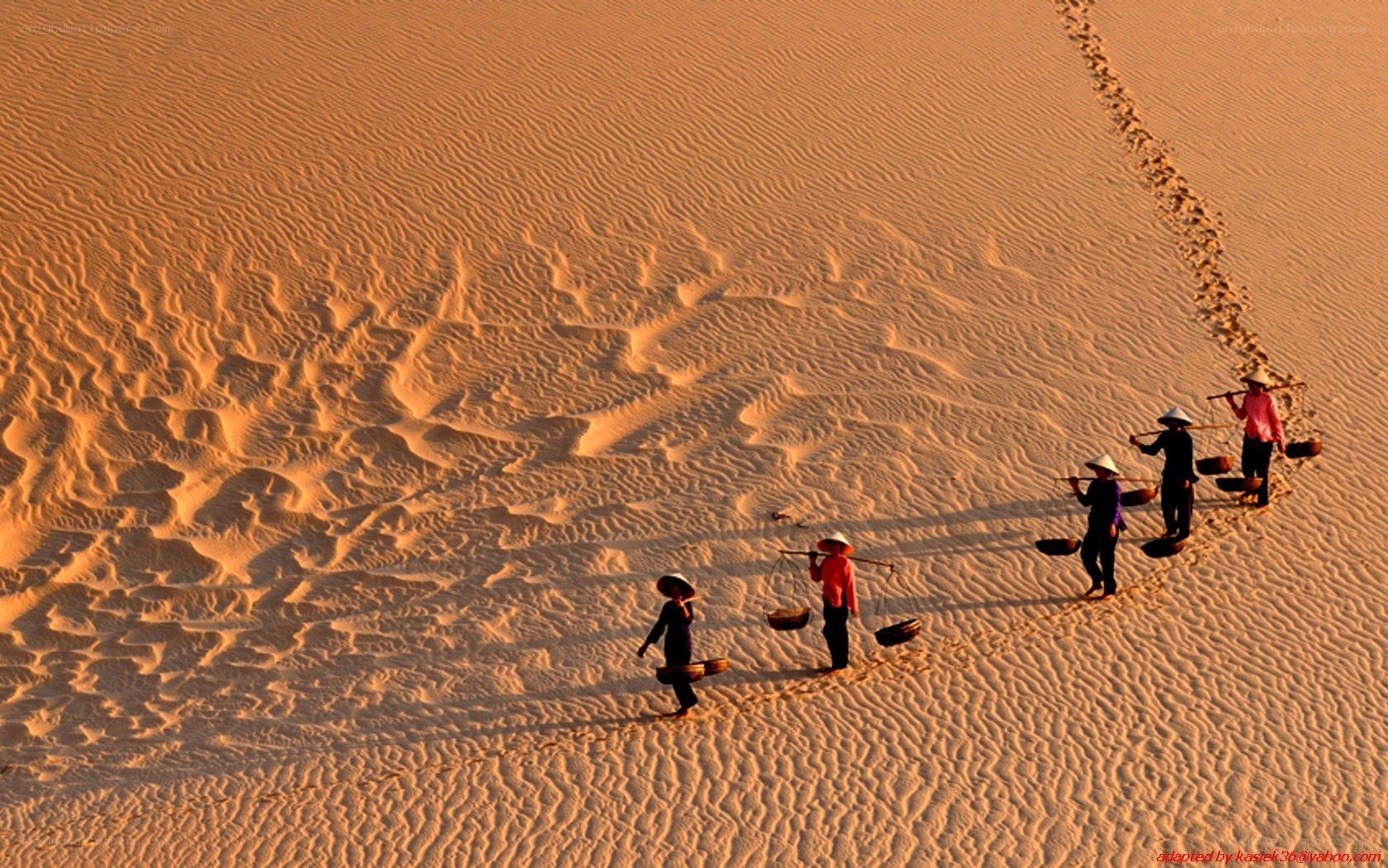 People carrying baskets on sand dunes