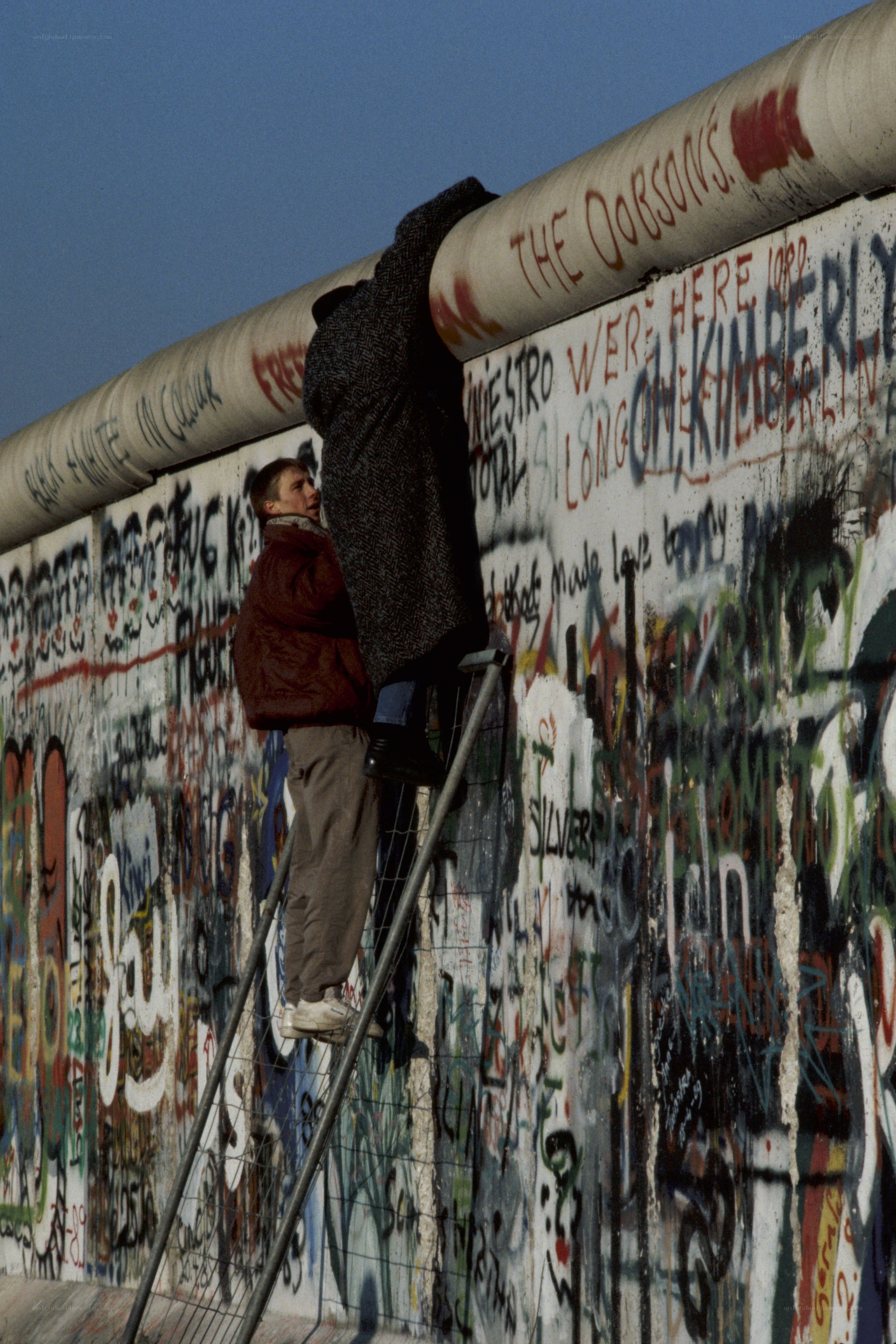 People climbing the Berlin Wall