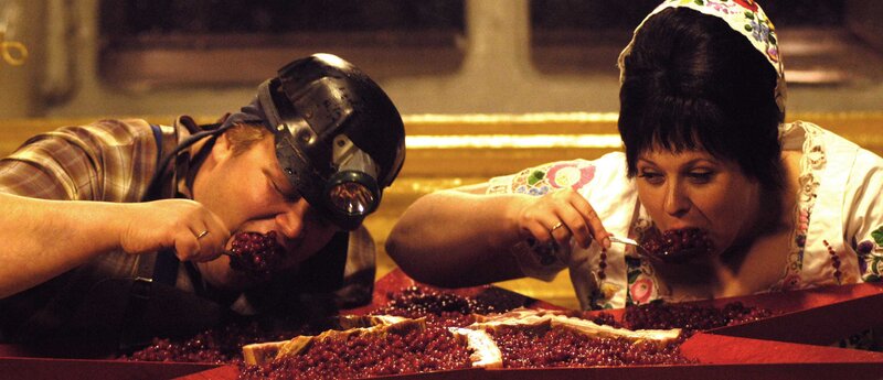 People eating berries from a large tray