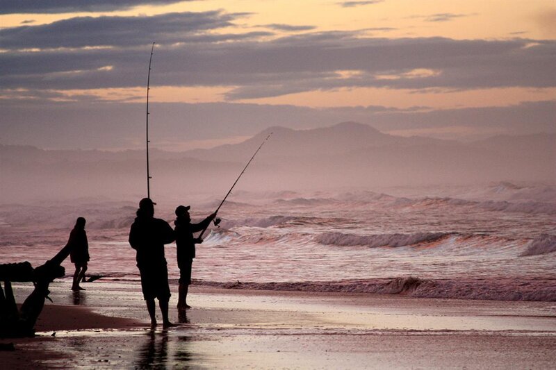 People fishing at sunset on the beach