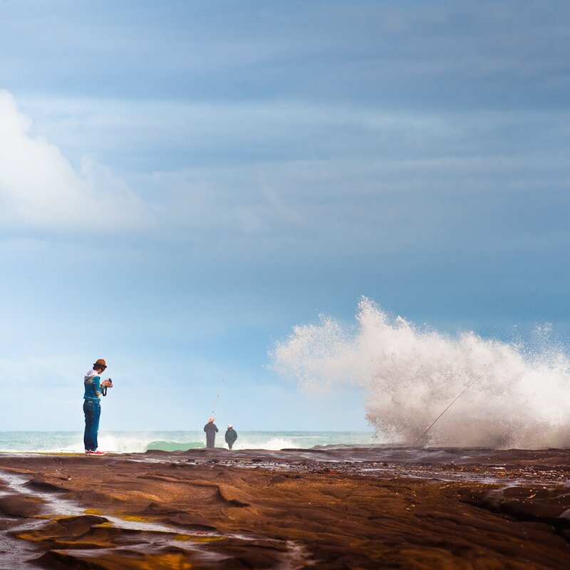 People fishing on rocky shore