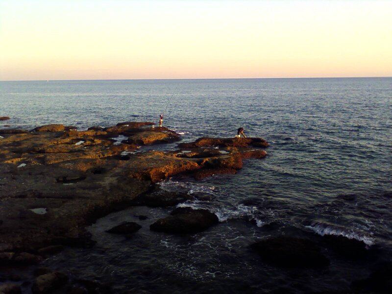 People fishing on rocky shore