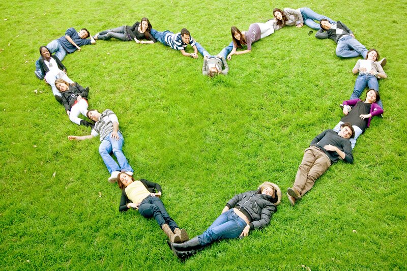 People forming heart shape on grass
