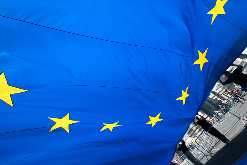 People holding a large EU flag