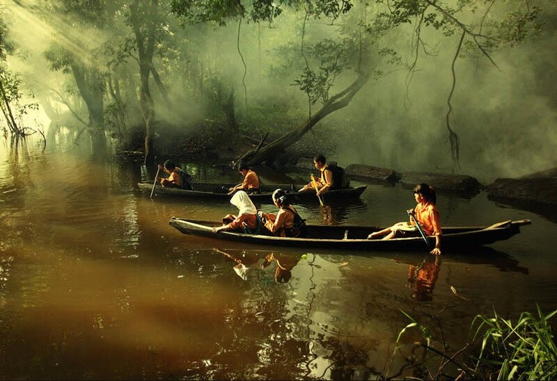 People in canoes on a misty river
